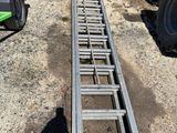 une échelle posée par terre à côté d'un tracteur