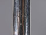 a close up of a silver metal pipe with a black handle