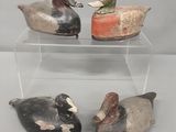 trois canards sont posés sur une vitrine transparente posée sur une table