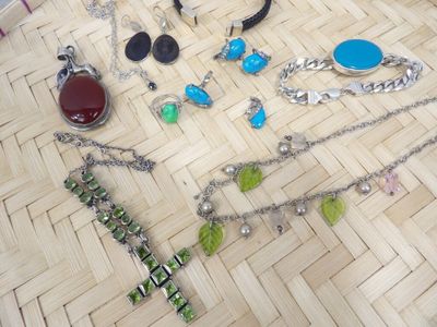 many different necklaces and bracelets laid out on the floor