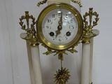 a white and gold clock sitting on top of a table