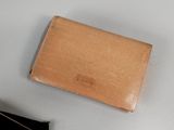 a small wallet sitting on a table next to a cell phone