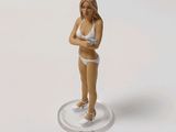 a figurine of a woman in a bikini standing on a coin