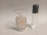 a small glass and a small glass bottle sitting on a table