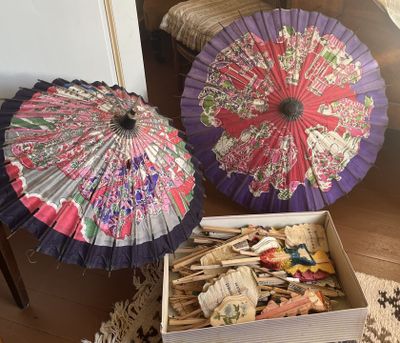 deux parapluies posés dans une boîte par terre