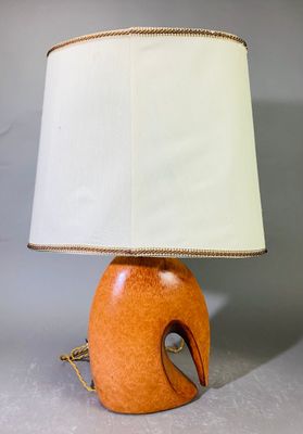 une lampe de table orange surmontée d'un abat-jour blanc