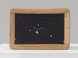 un petit tableau noir orné de perles colorées, posé sur une table