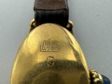 a close up of a gold watch with a leather strap