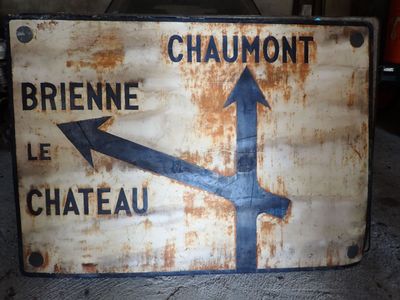 panneau métallique rouillé avec des flèches indiquant différentes directions