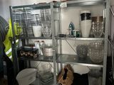 a man standing in front of a shelf filled with dishes