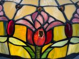 un gros plan d'une lampe en vitrail ornée d'une fleur