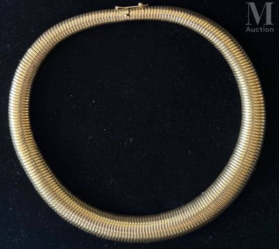a close up of a gold necklace on a black surface