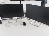 deux écrans d'ordinateur posés sur un bureau avec un clavier et une souris