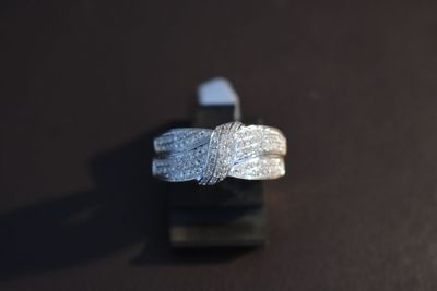 a silver ring with a knot on it on a black surface