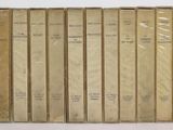 les dos des livres sont alignés sur une surface blanche