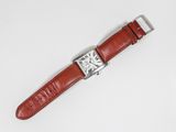 a close up of a watch on a white surface with a red strap