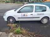 a small white car parked on the side of the road