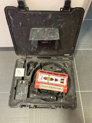 un étui noir contenant une cassette, posé par terre