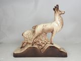 a figurine of a deer and a baby deer on a rock