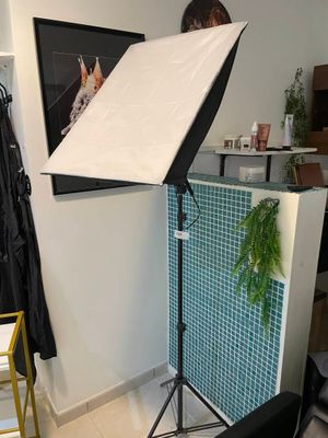 une image représentant un studio photo avec une lampe et une chaise