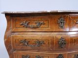 a wooden chest of drawers with a marble top