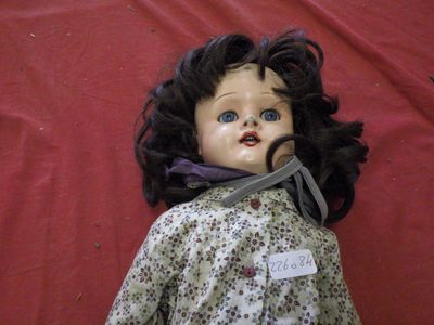 a close up of a doll on a red surface