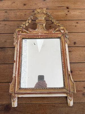 un miroir accroché au mur, avec une personne qui le photographie