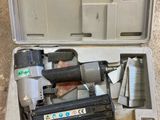 an open tool box with a stapler and a nail gun in it