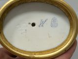 someone is holding a gold and white clock in their hand
