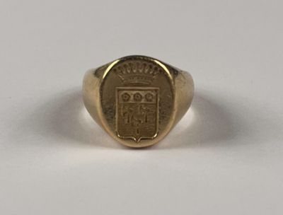 un gros plan d'une chevalière en or ornée d'un blason