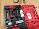 a red case with a nail gun and a pair of scissors