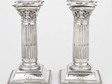 une paire de chandeliers anciens en argent sur socles, sur fond blanc