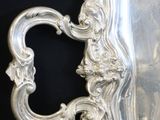 a silver tray with a handle on a black table
