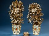 pair of antique vases with flowers and leaves on them next to a coin