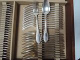 many forks and spoons in a wooden box