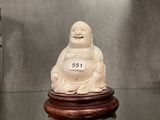 a white buddha statue sitting on top of a glass table
