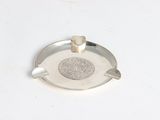 a silver ashtray on a white table with a silver ashtray