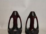 deux vases posés sur un socle transparent, sur une surface blanche