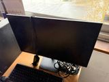 two monitors and a keyboard on a desk in front of a window