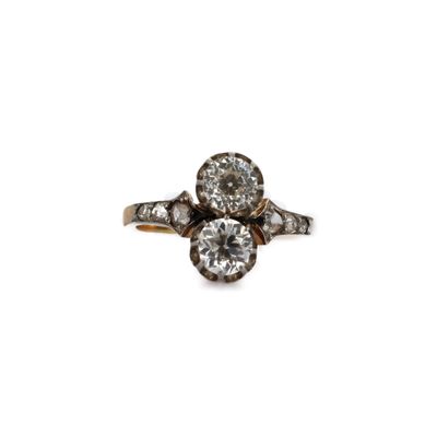 un gros plan d'une bague en diamant et en or sur fond blanc