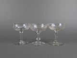 three wine glasses sitting on top of a table next to each other