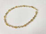 a close up of a gold chain bracelet on a white surface