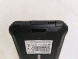 the back of a black cell phone sitting on top of a white table