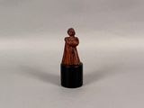 une image représentant une figurine miniature d'une femme sur fond blanc