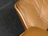 brown leather lounge chair and ottoman in a room with carpet