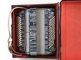 accordion in a red case on a white background
