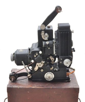 un vieux projecteur de cinéma posé sur une caisse en bois