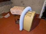a small air conditioner sitting on the floor in the corner of a room