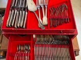 beaucoup d'argenterie dans une boîte rouge posée sur une table