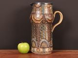 a vase and an apple sitting on a table